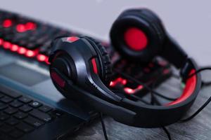 auriculares con detalles rojos en el teclado con botones rojos brillantes. auriculares para jugar, trabajar, escuchar música. foto