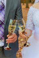 Bride and groom holding wedding champagne glasses photo