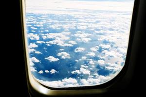 Fluffy white clouds and blue sky seen from airplane. photo