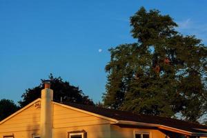 hermoso cielo azul y luna sobre la casa del techo foto