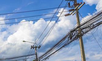 caos absoluto del cable en el poste de energía tailandés cielo azul de tailandia. foto