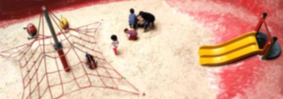 Blurry Children playground on sand yard  in central park. photo