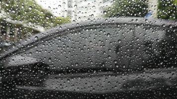 Rain drops on window with car background. photo