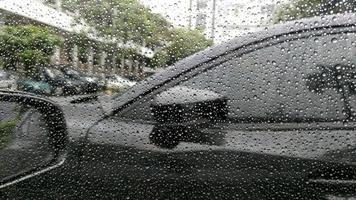 Rain drops on window with car background. photo