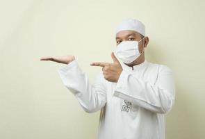 Portrait of Asian muslim man wearing mask with various gesture photo