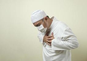 a asian muslim fat guy wearing mask feeling pain photo