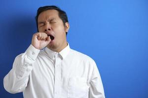 Sleepy tired Asian businessman yawning photo