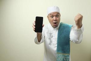 Fat Asian Muslim men looks surprised at the good news on phone photo