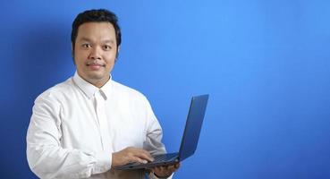 retrato de imagen fotográfica de un hombre de negocios asiático adulto de pie y sonriendo mientras sostiene una computadora portátil foto