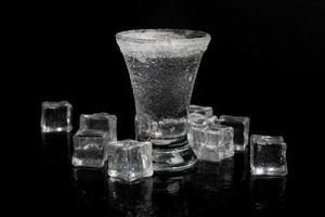 russian vodka with ice on a black table photo