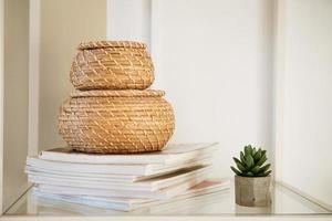 Close-up of a round straw box with a lid on a white shelf. photo