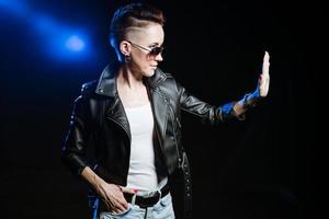 Stylish short haired brunette woman in black leather jacket wearing sunglasses photo