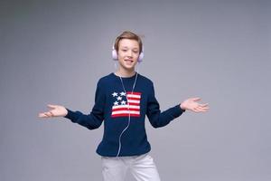 Joyful young man in blue sweater with flag america, stands listening to music photo