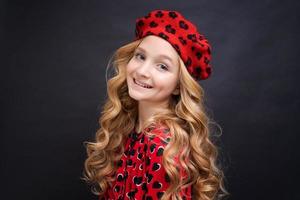 Pensive blonde little girl with long curly hair. Close-up portrait cute smiling photo