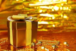caja de regalo dorada sobre fondo brillante foto