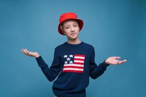 Smiling cheerful young guy in red panama hat and blue sweater with us flag photo