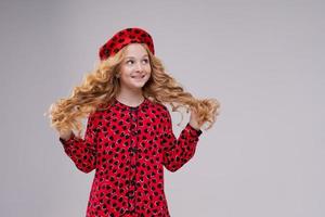 French fashion icon. Happy child wearing french red beret and dress on a light photo