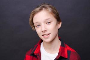 Close-up young smiling man in casual clothes in a red checkered shirt, posing photo