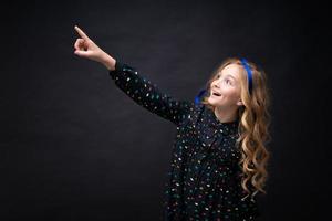 Close-up portrait gentle young caucasian girl with loose wavy hair on a black photo