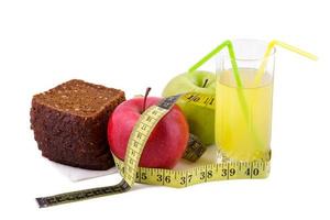 Rye bread apples and juice in  glass on a white background with a measuring tape photo