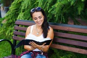 Freelance caucasian girl sits on bench and writes in a notebook. Education photo