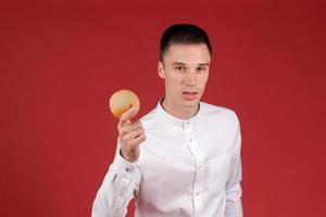 Young handsome man wearing white shirt standing over isolated red background photo