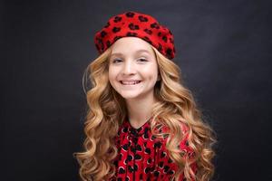 siguiendo su estilo personal. niña pequeña con un sombrero de estilo francés. chica feliz foto