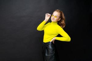 Cute caucasian teenager girl in a yellow t-shirt and black skirt posing photo