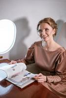 happy stylish woman sitting in a private plane to the window photo