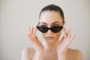 Woman face in sunglasses. Girl face close up portrait of woman. Young girl photo