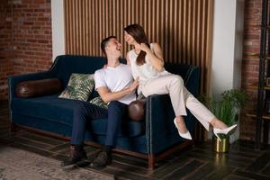 feliz joven pareja caucásica compradores de bienes raíces se regocijan sentados en el sofá foto