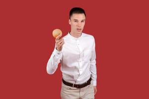 Young handsome man wearing white shirt standing over isolated red background photo