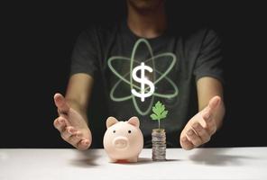 piggy bank saving money concept. with a coin and a dollar symbol between two hands photo