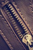 Macro of a open zipper of leather bag. Vintage style. Vertical image. photo