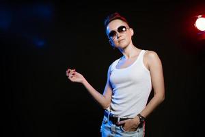 Caucasian stylish woman in sunglasses and a short haircut in rock style posing photo