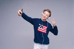 Cheerful young man in blue sweater posing on gray background, studio portrait. photo
