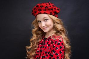 Pensive blonde little girl with long curly hair. Close-up portrait cute smiling photo