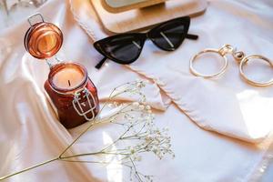 hay una vela decorativa en un frasco y vasos en la tela foto