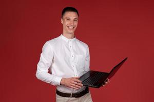 Portrait attractive focused cheerful brunette guy using laptop e-commerce photo