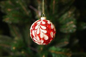 Primer plano macro de una sola bola decorativa roja de navidad colgando