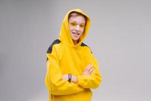 Funny curious young man in casual yellow sweatshirt, hood and yellow photo