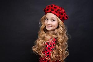 siguiendo su estilo personal. niña pequeña con un sombrero de estilo francés. chica feliz foto