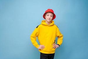 retrato de un tipo positivo con un suéter amarillo y un sombrero de panamá rojo en un azul foto