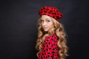 French fashion icon. Happy child wearing french red beret and dress on black photo