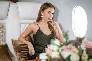 Beautiful rich woman in a private first class plane photo