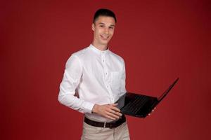 Holding laptop. Young Businessman using his laptop PC. Smiling handsome man photo