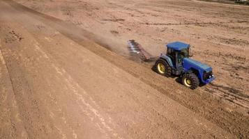 tractor plowing field top view, aerial photography with drone photo