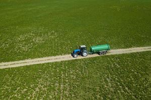 tractor con remolque fertilizando el campo con abono natural foto