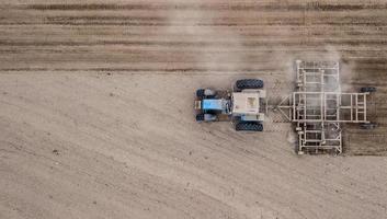 Tractor plowing field from right to left top view. Agriculture. Tillage. photo