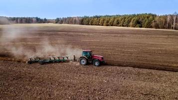 spring plowing field tractor aerial photography with drone photo